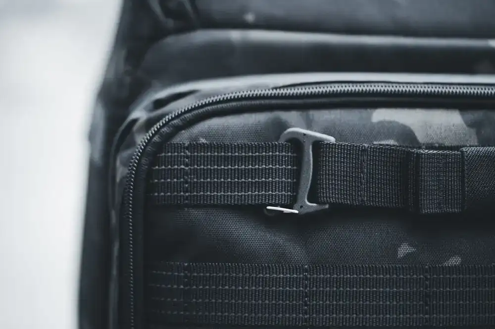 Tactical tech sling bag displaying utility zippers and straps