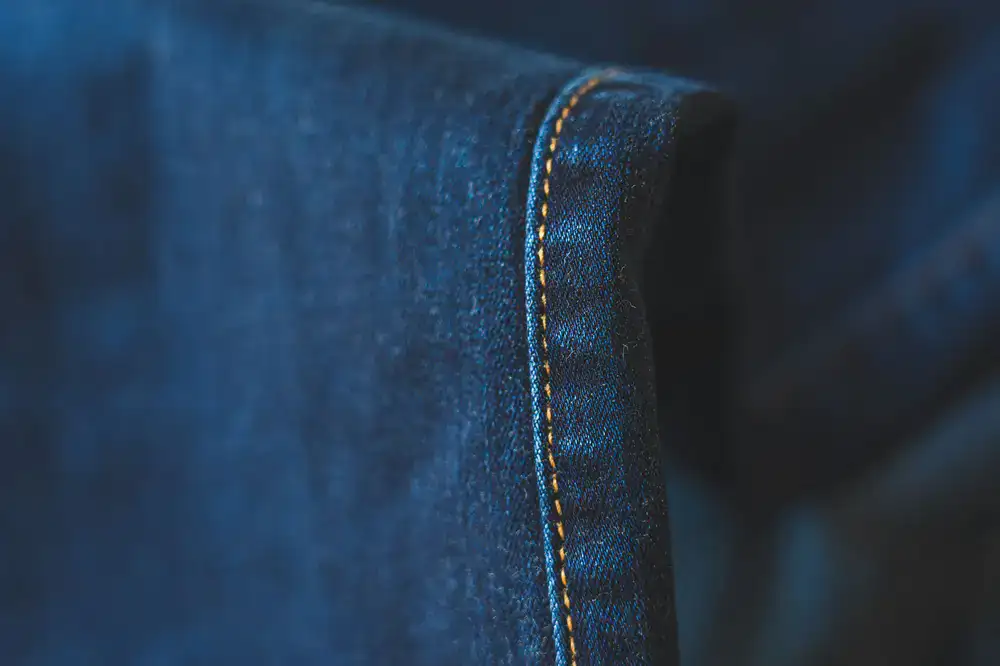 Macro view of heavy cotton fabric texture and bold neon stitching